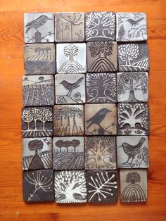 a wooden table topped with lots of different types of ceramic tiles on top of each other