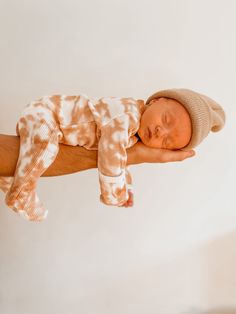 a man holding a newborn baby in his arms and wearing a knitted hat on it's head