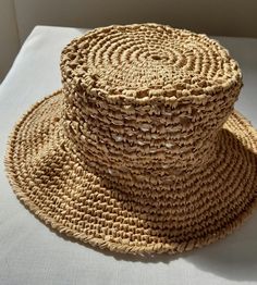 Looking for a hat to complement your style on hot summer days? This handmade raffia hat is for you! It offers a comfortable use thanks to its breathable beige raffia material. It is suitable for use both on the beach and in the city with its design in the style of a straw beach hat. This expertly crafted hat is handcrafted and crafted using sustainable materials. Express your style on your summer adventures with this comfortable, stylish and environmentally friendly hat. Casual Natural Color Straw Bucket Hat, Casual Natural Straw Bucket Hat, Natural Curved Brim Straw Bucket Hat, Casual Beige Paper Straw Bucket Hat, Beige Handwoven Wide Brim Bucket Hat, Beige Toquilla Straw Bucket Hat With Flat Brim, Natural Straw Casual Bucket Hat, Natural Straw Boater Hat For Beach, Beige Wide Brim Handwoven Bucket Hat