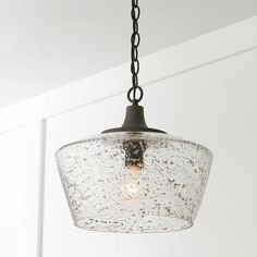 a light fixture hanging from a ceiling in a room with white walls and flooring