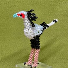 a beaded bird is standing on its hind legs