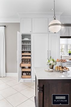 a large kitchen with white cabinets and marble counter tops, along with an island in the middle