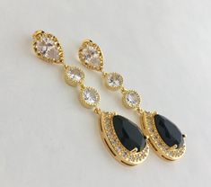 I've created these absolutely gorgeous super sparkly long black crystal earrings in gold plated brass setting. Earrings feature a large teardrop with pear cut black cubic zirconia center surrounded by tiny round zirconia crystals. Teardrop dangles from a bright cubic zirconia ear stud and two round cubic zirconia connectors. Total length of the earrings is 6 cms. For matching necklace click: https://www.etsy.com/listing/763689760/black-bridal-necklace-black-gold-crystal?ref=shop_home_active_2 Fo Elegant Gold Earrings With Black Diamonds, Glamorous Black Crystal Earrings For Wedding, Black Wedding Jewelry, Black Gold Earrings, Black Crystal Earrings, Pink Pearl Earrings, Black Bridesmaid, Black Bridesmaids, Black Gold Jewelry