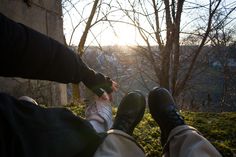 two people sitting on the ground with their feet up