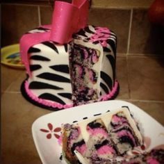 two zebra print cakes with pink frosting on them sitting on a plate next to each other