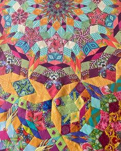 a colorful quilt with many different designs on it's sides and the center piece in the middle