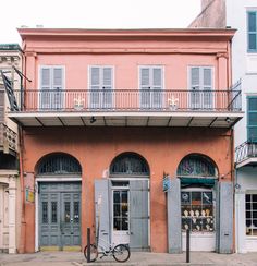 a bicycle parked in front of a building with shutters on the doors and windows