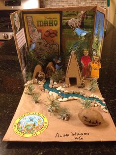 an open cardboard box with pictures and rocks on the inside, sitting on a counter top