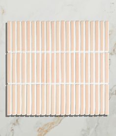 a white marble tile with thin strips of wood on the top and bottom, all lined up in rows