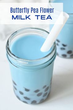 a glass jar filled with blue liquid and a white straw