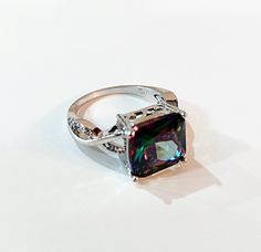 This large sparkly sterling silver mystic topaz ring is from an Estate.  It is size 9 and the setting measures 7/16" wide and 3/8" tall.  The beautiful setting features small diamond like stones set in a swirl design on the side and a filigree design around the stone.  While I do not know the carat weight, I did have a jeweler confirm it is mystic topaz and sterling silver but cannot confirm the type of small stones on the side.  This beautiful stone reflect many different colors at different angles. This will be shipped in a gift box, via USPS Ground Advantage which is insured. Please note:  This is a used vintage ring that appears to be in excellent condition. I believe the actual value is likely much more than what I'm asking but since jewelry is not my specialty, I cannot guarantee any Luxury Multi-stone Topaz Ring In Sterling Silver, Mystic Topaz Ring, Filigree Design, Mystic Topaz, Swirl Design, Vintage Ring, Topaz Ring, Cocktail Ring, Stone Settings