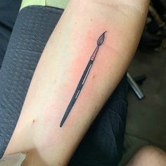 a black and white photo of a knife tattoo on the left upper arm, which has a fork in it