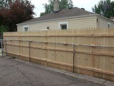 a wooden fence is in front of a house