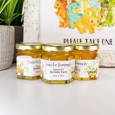 three jars of honey sitting on top of a table