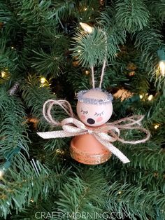 a christmas ornament hanging on a tree with lights in the background and text overlay that says how to make an angel ornament