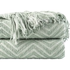 two green and white blankets folded on top of each other with fringes in the middle