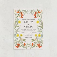 an image of a wedding card with flowers and leaves on the front, in white background