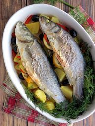 two fish are in a bowl with vegetables