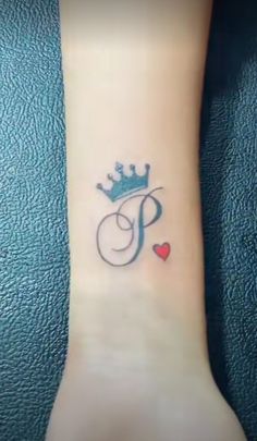 a small wrist tattoo with a crown and heart on the left side of the wrist