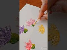 someone is drawing flowers with colored pencils on paper and then they are being drawn