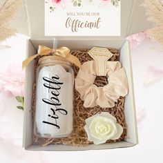 a gift box with two bottles and flowers on the table next to it is a card that says, will you be our affirantt?