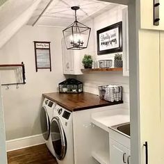 a washer and dryer in a small room with wood flooring on the walls