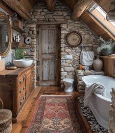 a rustic bathroom with stone walls and wood floors