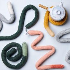 the word snake spelled out in different colors and sizes with various objects around it on a white surface