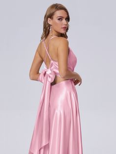 a woman wearing a pink dress with a bow on the back