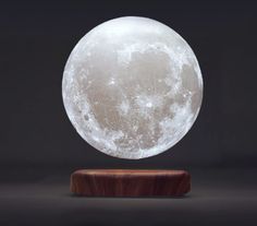 a large white moon sitting on top of a wooden stand