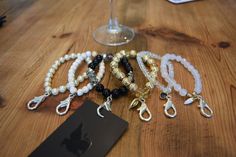 several bracelets are sitting on a table next to a wine glass and a card