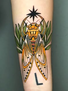 a tattoo design on the arm of a person with a yellow and black insect on it