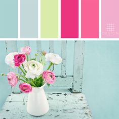 a white vase filled with pink and white flowers