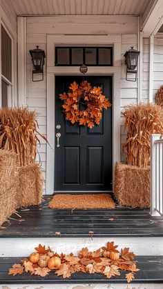 a front porch with hay bales and pumpkins