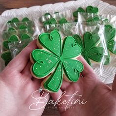 someone is holding some shamrock cookies in their hand