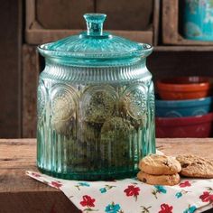 a glass jar filled with cookies sitting on top of a table