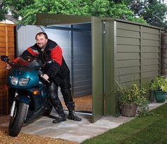 a person on a motorcycle in front of a shed