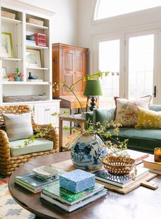 a living room filled with lots of furniture and books on top of a coffee table