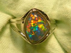 "Occasionally someone requests a Men's  Opal ring that is unique, a one off, impossible to duplicate, here's an example of that. It is impossible to mass produce free form Men's rings as each stones size & shape is different. This means that each ring needs to be individually custom built. This ring features a 15x11 mm Free Form, Natural Triplet Opal of Gem Plus quality. The  shank is made from Sterling Silver (925) & features some slight engraving on the sides of the shank but is otherwise basically plain. The ring is semi J backed with ornate workings  The Gem Plus grade Triplet Opal was mined at the 12 Mile field in Coober Pedy in South Australia & is an example of the very best Quality of a Natural Triplet Opal. The Quartz cap on the stone is very hard & scratch resistant. We offer a l Opal Mens Ring, Coober Pedy, Opal Ring, Men's Rings, Natural Opal, Ring Sterling Silver, Opal Rings, Sterling Ring, Sterling Silber