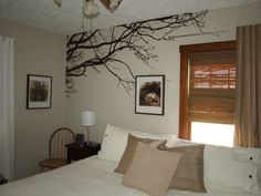 a bed with pillows and pictures on the wall above it, along with two windows