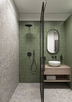 a green tiled bathroom with a shower and sink