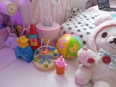 a teddy bear sitting on top of a bed next to toys