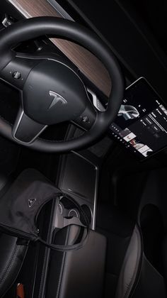 the interior of an electric vehicle with its steering wheel and display screen showing information about it