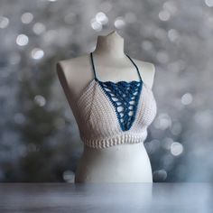 This one of a kind bralette will make you stand out wherever you go!  Featuring:  Deep V blue shell detailing! White ribbing around the waist! A criss cross back! Made in both white and turquoise 100% acrylic yarn.  Perfect for festivals with high waisted denim shorts or harem pants!  Bralette pictured is made to fit size medium and is ready to dispatch!  Full Sizing details:  Small - A-B cup  Medium - B-C cup Large - D cup  XL - DD cup Sizes vary depending on the coverage you want so if you aren't sure what size to get or want it made to your exact bra size please message me.   Items can be machine washed at 30o and laid flat for drying. All items with decorative charms or beading should be hand washed in Luke warm water and laid flat for drying. DO NOT TUMBLE DRY.  Custom orders in other Spring Festival Crop Top With Built-in Bra, White Halter Neck Crop Top With Built-in Bra, White Triangle Crop Top With Built-in Bra, White Halter Crop Top With Built-in Bra, Festival Bra Friendly Cropped Top, White Crop Top With Built-in Bra And Triangle Shape, White Crop Halter Top With Built-in Bra, Bohemian Crop Top With Built-in Bra For Festivals, Cropped Crop Top With Built-in Bra For Beach