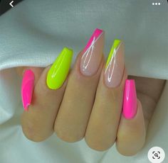 a woman's hand with neon pink and green nails