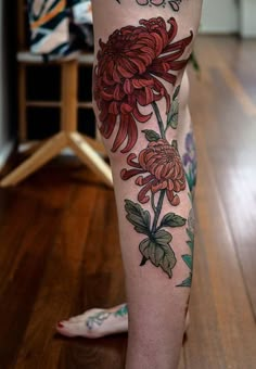 a woman's leg with flowers on it and the word love is written in black ink