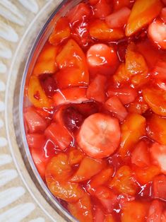 a glass bowl filled with sliced fruit on top of a table