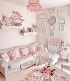 a living room filled with white furniture and pink accessories on top of a wooden floor