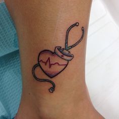 a small heart with a stethoscope tattoo on the side of her ankle