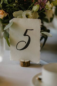 a table number with flowers in the background